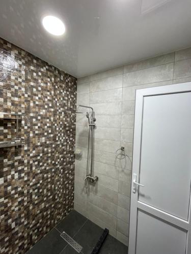 een badkamer met een douche en een glazen deur bij Enzo home in Batoemi