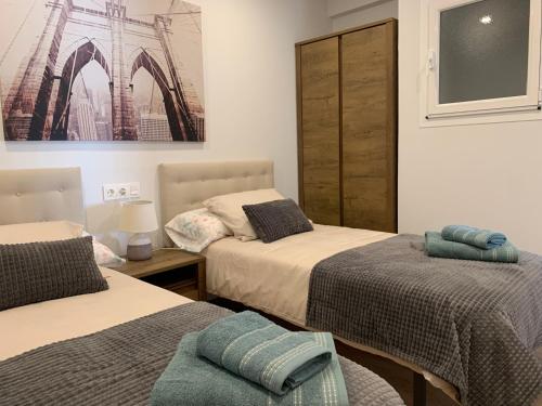 a bedroom with two beds and a picture on the wall at URBANIZACION CON PISCINA ARNELAS SANXENXO in Sanxenxo