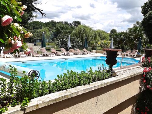 une piscine avec des chaises et une fontaine dans l'établissement GRANDE VILLA en TOURAINE, à Tournon-Saint-Pierre