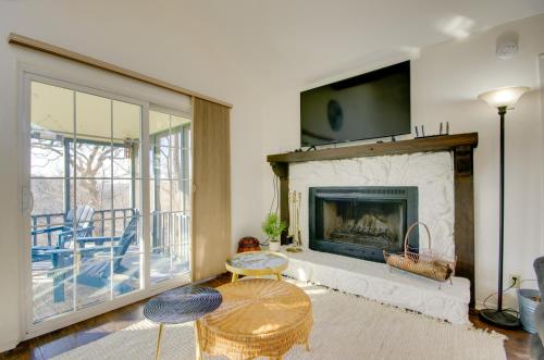 a living room with a fireplace with two chairs and a table at Furnished Porch! Margaritaville Resort Family Stay in Osage Beach