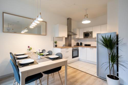 une cuisine et une salle à manger avec une table et des chaises dans l'établissement Lovely Cosy Apartment Terrace - 5 min DISNEYLAND Paris, à Serris