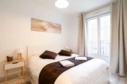 une chambre blanche avec un grand lit et une fenêtre dans l'établissement Lovely Cosy Apartment Terrace - 5 min DISNEYLAND Paris, à Serris