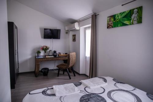 a bedroom with a bed and a table with a television at Auberge Sainte Marguerite in La Garde