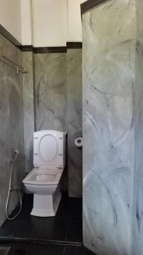 a bathroom with a white toilet and a shower at Nuwara Eliya Holiday Home in Nuwara Eliya