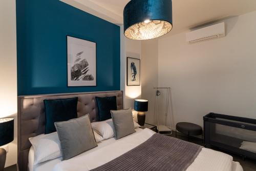 1 dormitorio con 1 cama grande y pared azul en Apartmány Mia Valtice en Valtice
