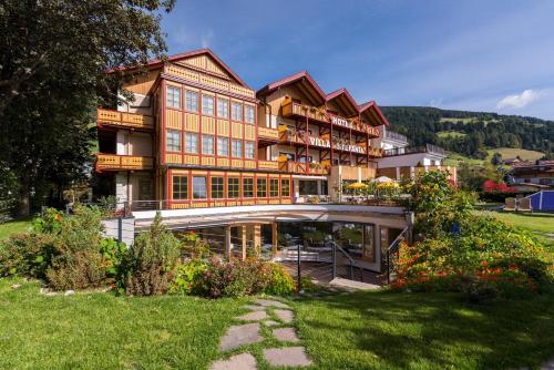 a large building with a garden in front of it at Hotel Villa Stefania in San Candido