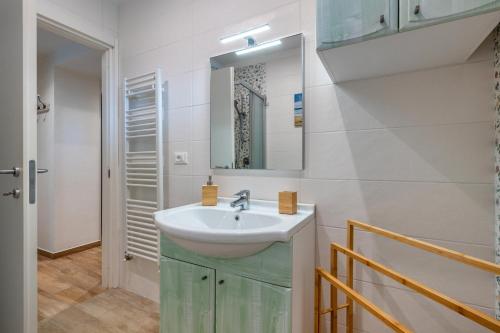 een badkamer met een wastafel en een spiegel bij Cà Frighilin in Finale Ligure