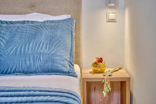 a bed with a blue pillow and a toy on a table at Sunflower Suites Gouvia Corfu in Gouvia