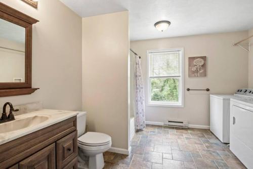 a bathroom with a sink and a toilet and a window at Spacious Wine Country Retreat Close to Ithaca in Lansing