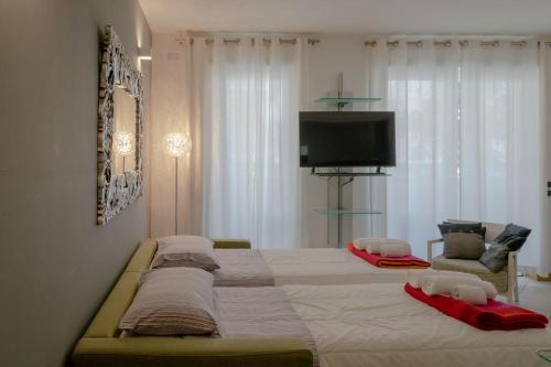 a large bed with two pillows and a television in a bedroom at Riva Central Apartment - Free Parking in Riva del Garda