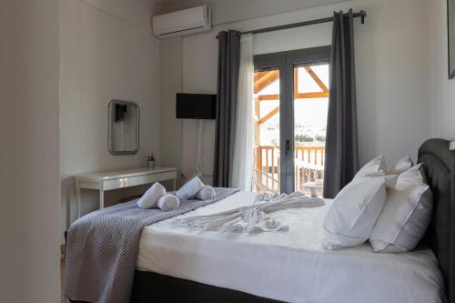 Schlafzimmer mit einem großen weißen Bett und einem Fenster in der Unterkunft Felicia Home in Gouves