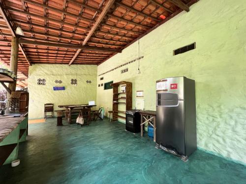 a kitchen with a refrigerator in the middle of a room at Hostel Moreré in Moreré