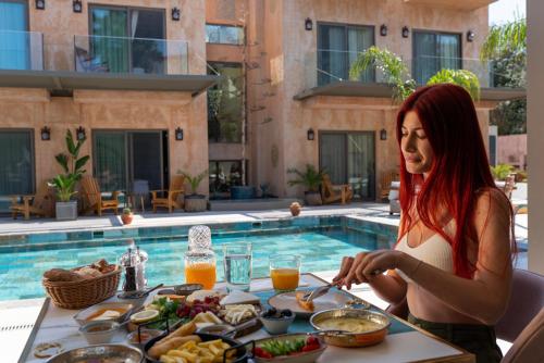 a woman sitting at a table with a tray of food at Sezz Hotels Spa Wellness Yalikavak Adult Only in Yalıkavak