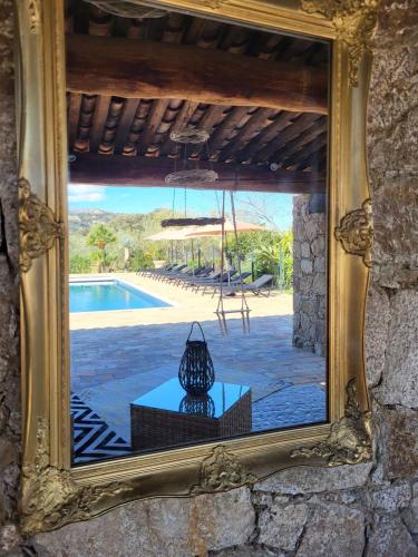 a mirror reflection of a table and a pool at Domaine du Reginu in Santa-Reparata-di-Balagna