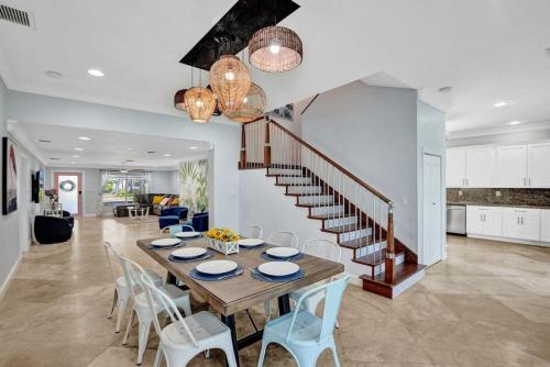 a dining room with a table and chairs and a staircase at Hot Tub! Roof Top! Firepit! Boat Dock! in Fort Lauderdale