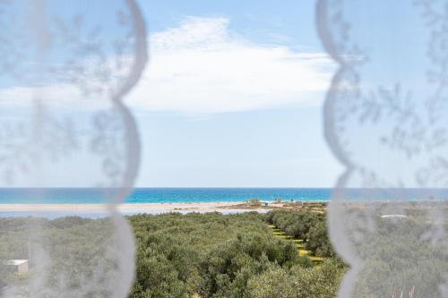 a view of the beach through a glass window at Endless Blue in Xerokampos
