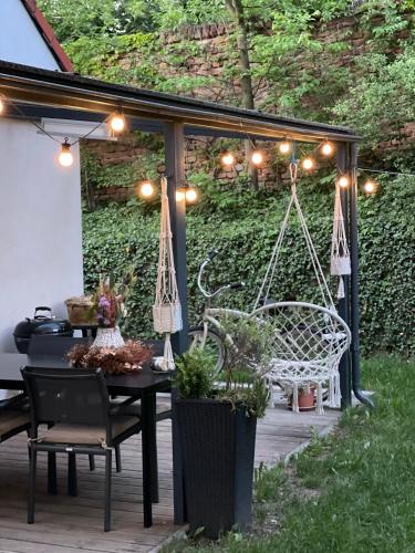 a patio with a swing and a table and chairs at Vila Mia Valtice in Valtice