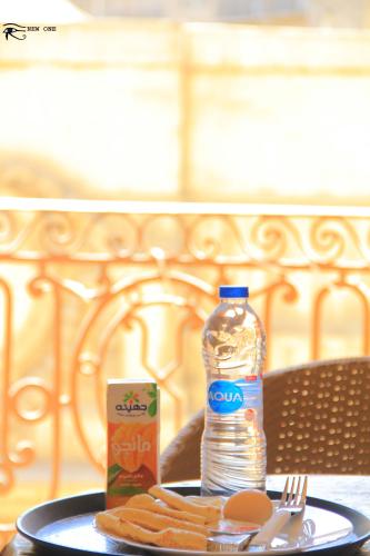 a table with a plate of food and a bottle of water at New One Hotel in Cairo