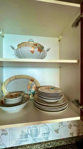 a shelf filled with plates and bowls in a kitchen at Centaurus Two Bedroom Apartment in Islamabad