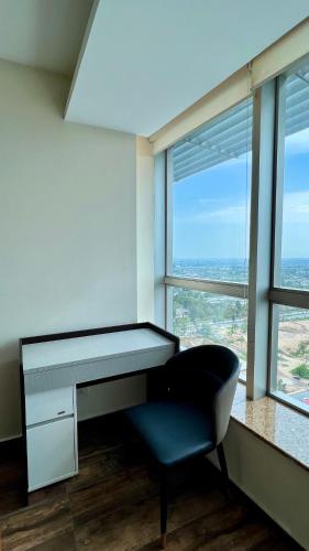 a desk and a chair in a room with windows at Centaurus Two Bedroom Apartment in Islamabad