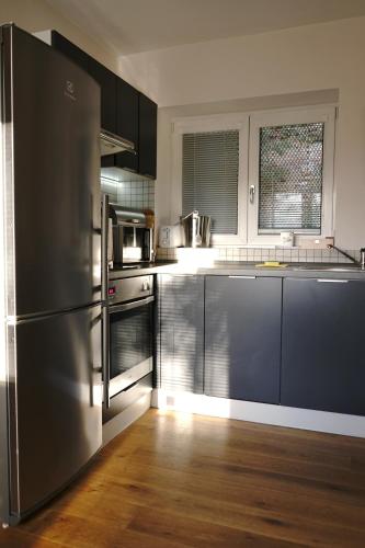 a kitchen with a stainless steel refrigerator and wooden floors at Vila Mia Valtice in Valtice