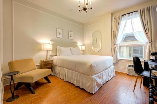 sypialnia z łóżkiem, krzesłem i oknem w obiekcie The Windsor Hotel by Hoco Hotels Collection w mieście Stratford