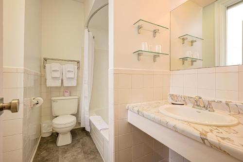 bagno con lavandino, servizi igienici e specchio di The Windsor Hotel by Hoco Hotels Collection a Stratford