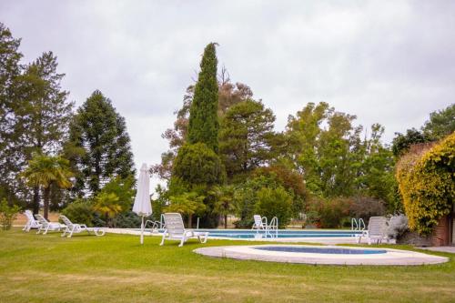 a group of chairs sitting around a swimming pool at Hotel Suizo in Colonia Suiza