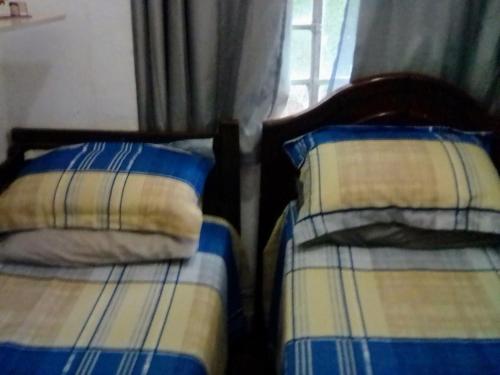 twee bedden met kussens naast een raam bij Cantinho do Thiê in Paqueta