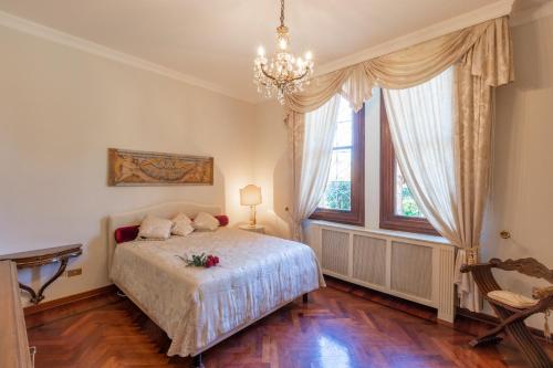 um quarto com uma cama e um lustre em Villa Liberty a soli 20km da Venezia em Mira