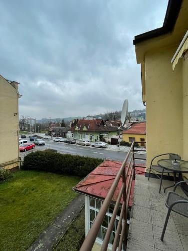 a balcony with a table and a view of a street at Penzion Agape in Luhačovice