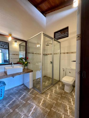 a bathroom with a shower and a toilet and a sink at The Bluesky Apartment in Unawatuna
