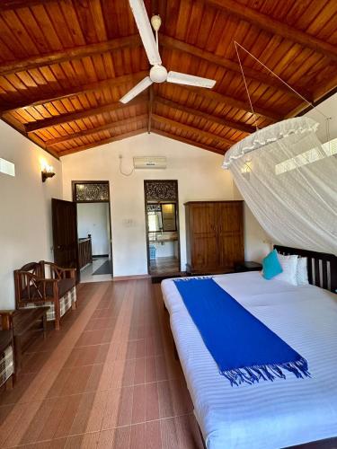 a bedroom with a large bed with a ceiling fan at The Bluesky Apartment in Unawatuna
