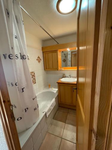 La salle de bains est pourvue d'une baignoire et d'un rideau de douche. dans l'établissement Vue splendide Mont Blanc, à Saint-Gervais-les-Bains