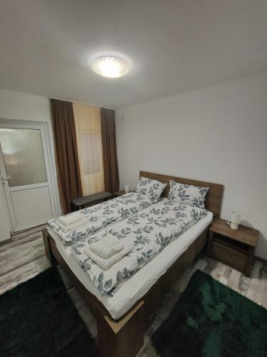a bedroom with a large bed with a white comforter at Smile apartments in Sighişoara