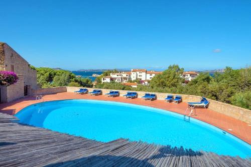 una gran piscina con tumbonas en Le Terrazze Di Baja Sardinia, en Baja Sardinia