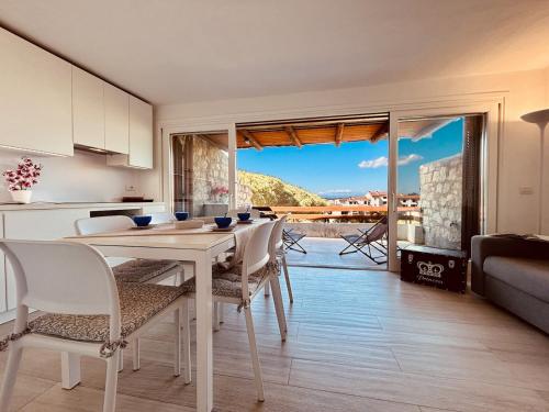 cocina y comedor con mesa y sillas en Le Terrazze Di Baja Sardinia, en Baja Sardinia