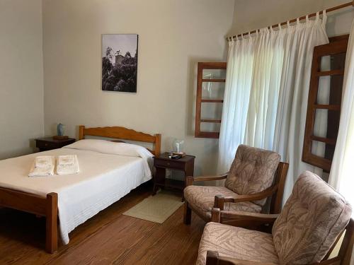 - une chambre avec un lit et une chaise dans l'établissement Hotel Suizo, à Colonia Suiza