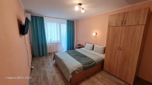 um quarto com uma cama grande e uma janela grande em Apartment Home comfort in Nikolaev em Nikolayev