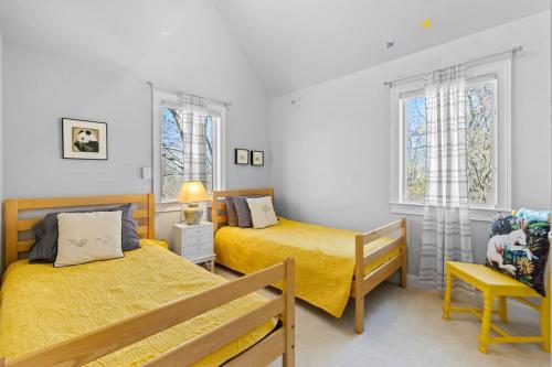 1 Schlafzimmer mit 2 Betten, einem Stuhl und Fenstern in der Unterkunft Relaxing Hideaway - Spacious Home in Spring Hill