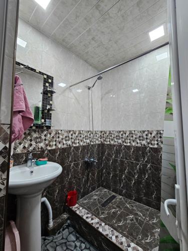 een badkamer met een wastafel en een douche bij Sunny Apartment close to Erebuni mall in Jerevan