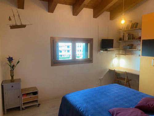 a bedroom with a blue bed and a window at fabio strano in Spresiano