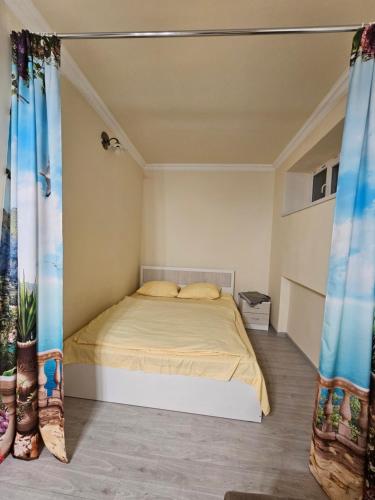 a bedroom with a bed in a room with curtains at Sunny Apartment close to Erebuni mall in Yerevan