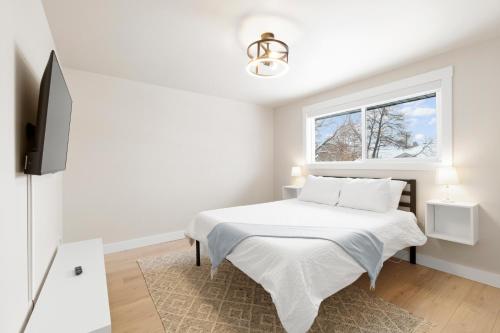 um quarto branco com uma cama e uma janela em Modern Home near Salt Lake's Attractions em Salt Lake City