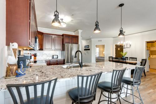 a kitchen with a large island with bar chairs at Lakefront Condo with Pool Access in Osage Beach! in Osage Beach