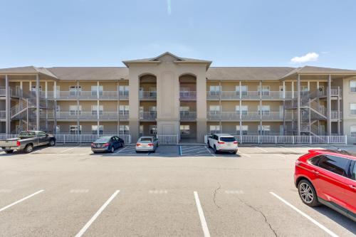 a large apartment building with cars parked in a parking lot at Lakefront Condo with Pool Access in Osage Beach! in Osage Beach