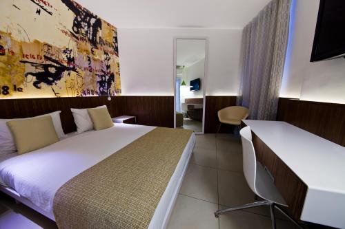 a hotel room with a bed and a desk at Prima Vera in Jerusalem
