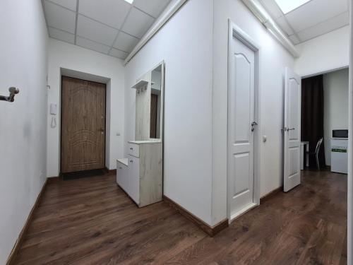 un corridoio con pareti bianche, pavimenti in legno e una porta di 2-room Luxury Apartment on Sobornyi Avenue 192, by GrandHome a Zaporižžja