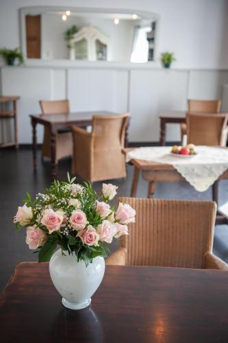 a vase filled with pink roses sitting on a table at Le Maissin 1876 in Paliseul