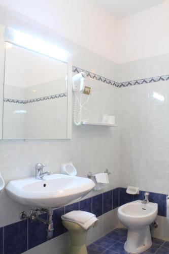 bagno con lavandino, servizi igienici e specchio di PARK HOTEL a Chianciano Terme